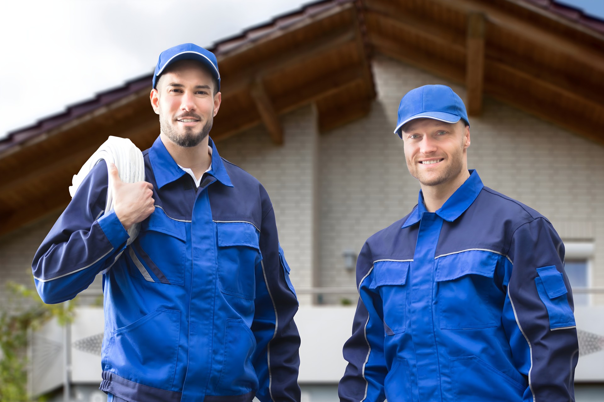 Two Male Electrician In Front Of House